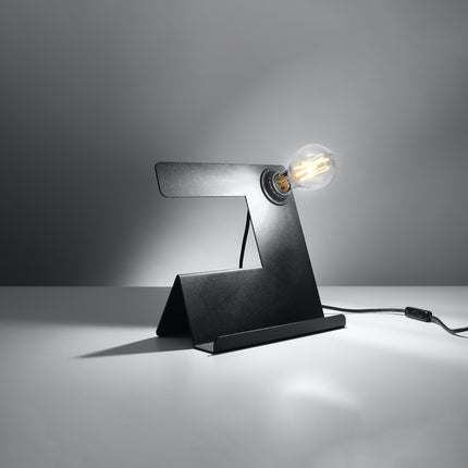 Lampe de table Support noire en acier de trois quarts, ampoule filament allumée, ambiance grise.