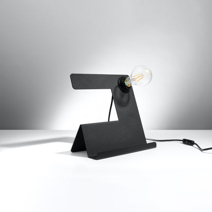 Lampe de table Support noire en acier, plaque pliée avec ampoule E27 apparente allumée sur fond gris.