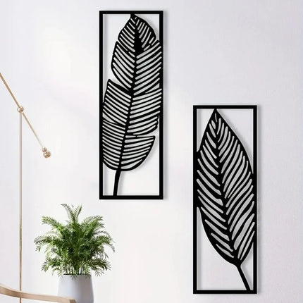 Lot de 2 feuilles murales en métal noir dans des cadres rectangulaires sur un mur blanc, près d'une plante verte