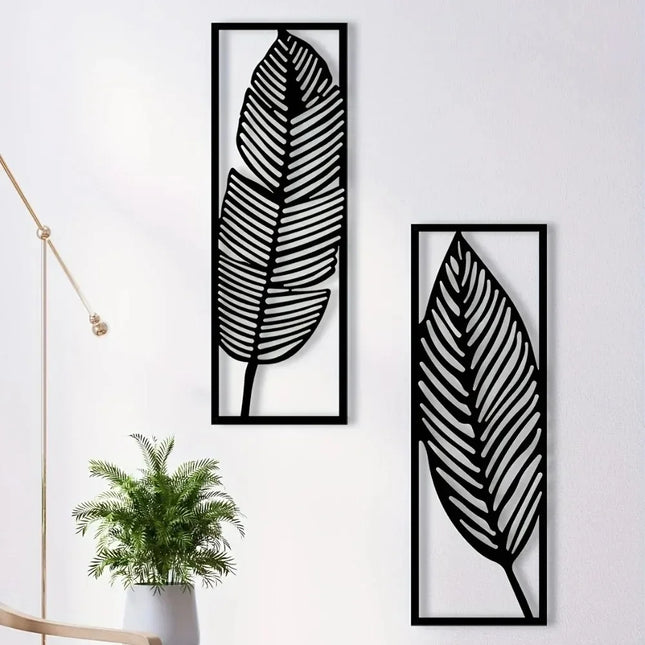 Lot de 2 feuilles murales en métal noir dans des cadres rectangulaires sur un mur blanc, près d'une plante verte