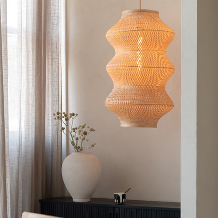 Luminaire en bambou tressé naturel sur fond blanc, silhouette arrondie et ajourée.