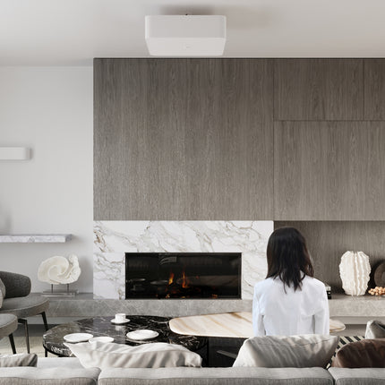 Luminaire carré blanc de la collection installé dans un salon contemporain avec cheminée