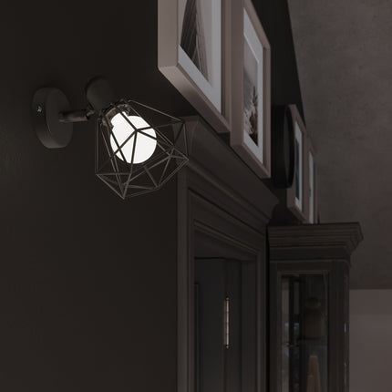 Gros plan sur une cage diamant noire en fil d'acier diffusant une lumière chaude, ambiance tamisée