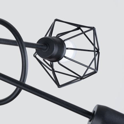 Gros plan sur une cage diamant en fil d'acier noir avec ampoule visible, détail du lustre plafonnier