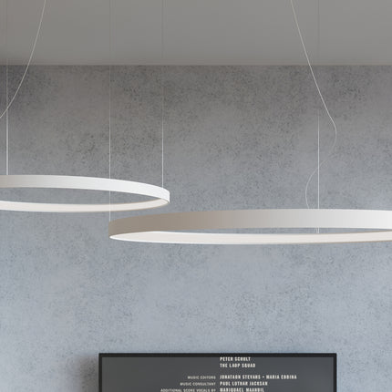 Trois lustres Anneau Solis blancs en cascade dans un salon lumineux