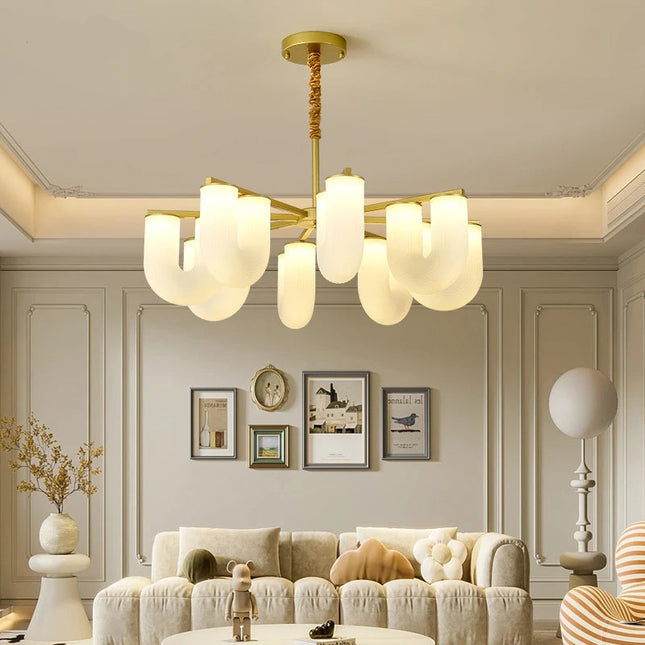 Lustre nordique forme U doré suspendu au-dessus d'un canapé dans un salon beige contemporain