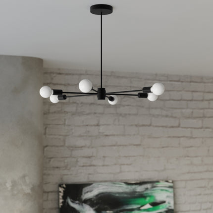 Lustre Satellite 5 noir allumé au-dessus d'un salon contemporain, mur en brique blanchie et tableau abstrait