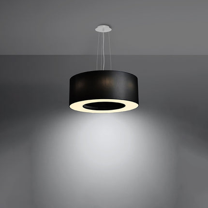 Lustre Saturne 50 noir allumé diffusant une lumière chaude vers le bas par son disque central