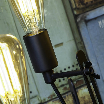 Gros plan sur une douille E27 noire et son ampoule à filament sur le lustre Seattle