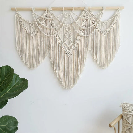 Macramé mural bohème installé en tête de lit dans une chambre