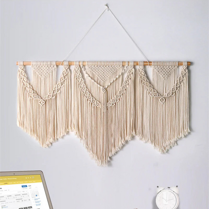 Détail des franges et du bâton en bois d'un macramé mural