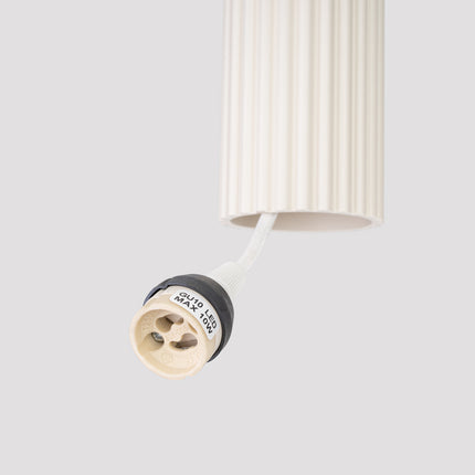 Détail de la finition nervurée d'un abat-jour cylindrique beige de la suspension Oslo