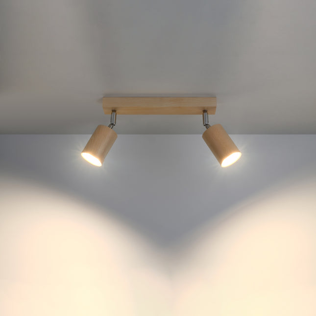 Plafonnier double spot en bois naturel allumé au plafond, deux faisceaux chauds dirigés vers le bas