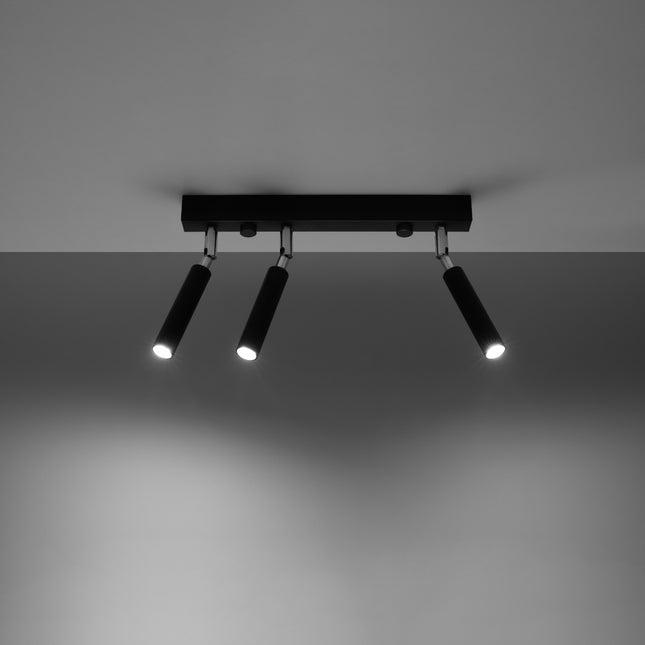 Plafonnier 3 spots acier noir fixé au plafond, faisceaux lumineux allumés