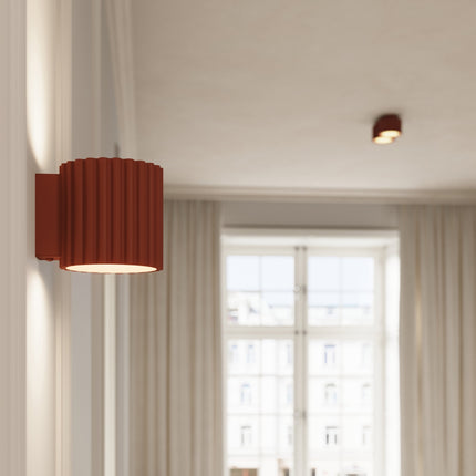 Plafonnier et applique Aura rouge ocre dans un intérieur clair près d'une fenêtre
