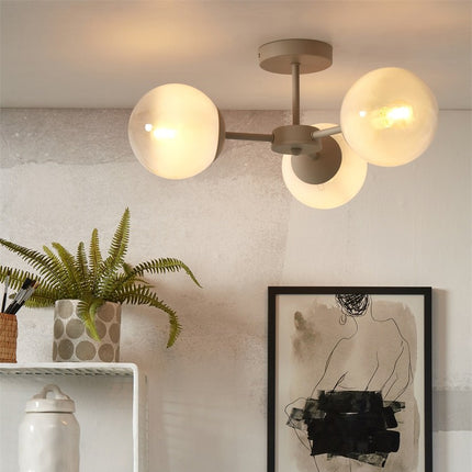 Plafonnier Aspen blanc lait allume au plafond d'un salon scandinave