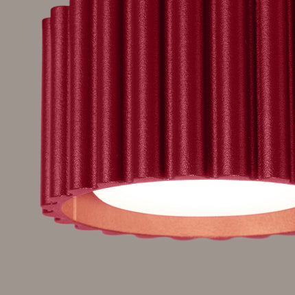Détail de la surface cannelée en aluminium bordeaux mat du plafonnier Aura