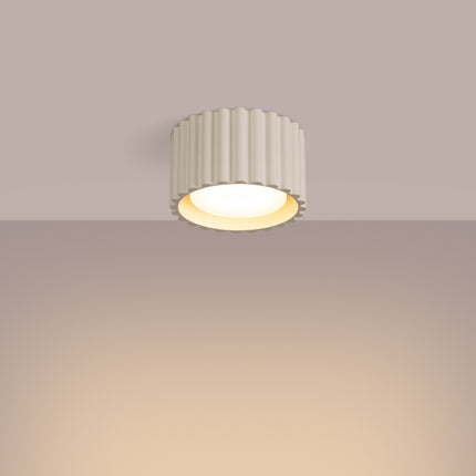 Plafonnier Aura beige allumé au plafond, halo de lumière chaude vers le bas
