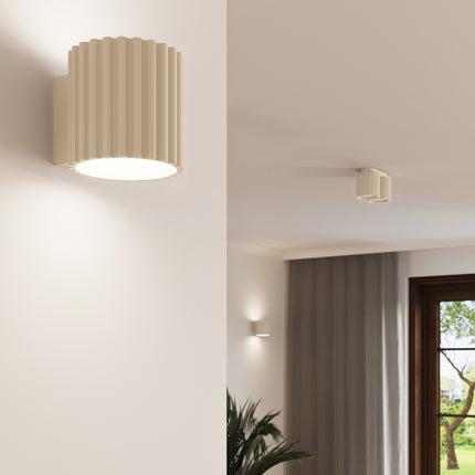 Luminaire Aura beige cannelé en ambiance intérieure, installé au mur et au plafond