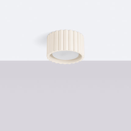 Plafonnier Aura beige cannelé fixé à un plafond blanc, éteint