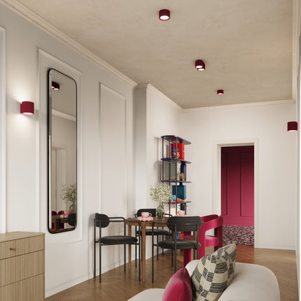 Plafonniers et applique AURA bordeaux dans un séjour lumineux aux moulures blanches
