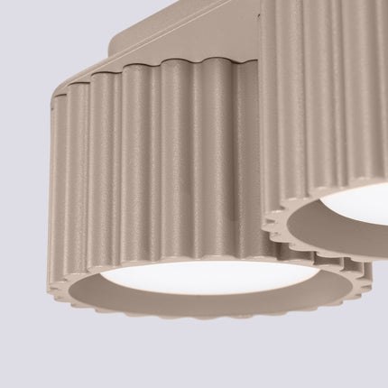 Détail du relief cannelé et de la finition mate taupe de l'aluminium du plafonnier Aura