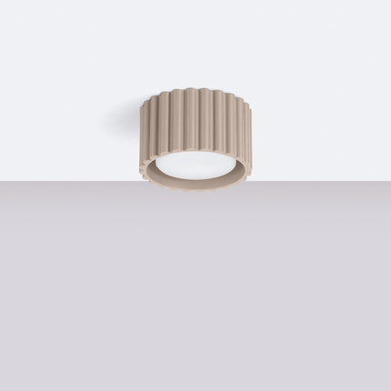 Plafonnier Aura taupe installé au plafond blanc d'un intérieur épuré