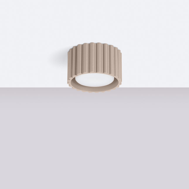 Plafonnier Aura taupe installé au plafond blanc d'un intérieur épuré