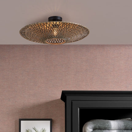 Bali ceiling light in braided black and natural bamboo installed on the ceiling of a bedroom, diffusing a warm light