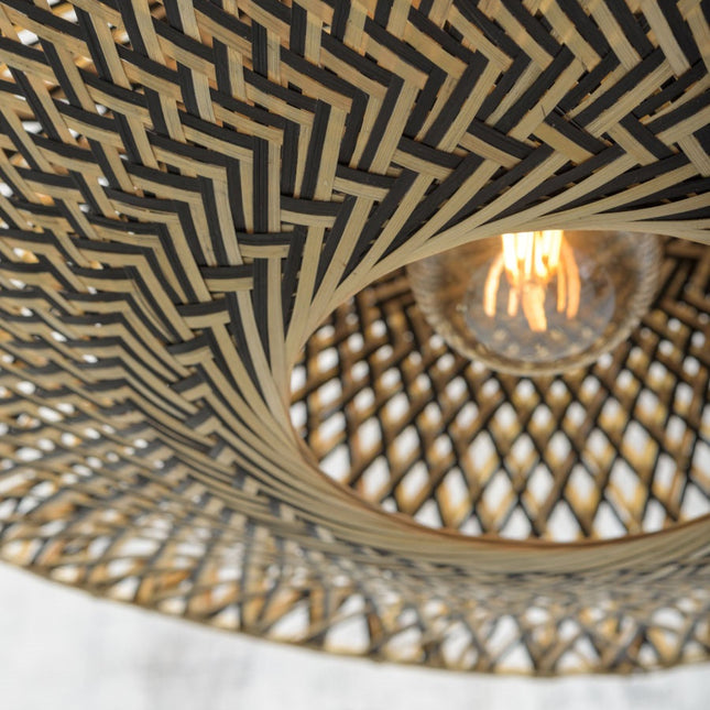 Vue rapprochée du tressage en bambou noir et naturel du plafonnier Bali, motif chevron autour de l'ampoule