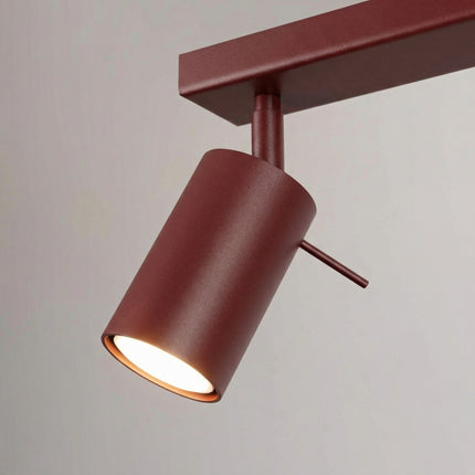 Plafonnier Barre 4 Spots Orientables Bordeaux, vue sur fond coloré