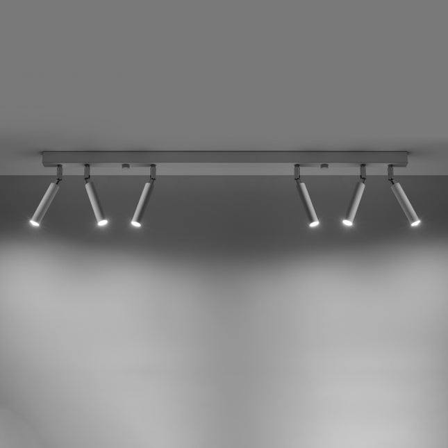 Barre de spots orientables blanche allumee, six faisceaux diriges vers le sol