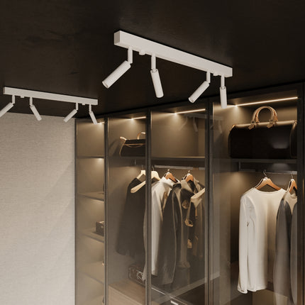 Rampe de spots orientables blanche au plafond d'un dressing, penderie eclairee en detail