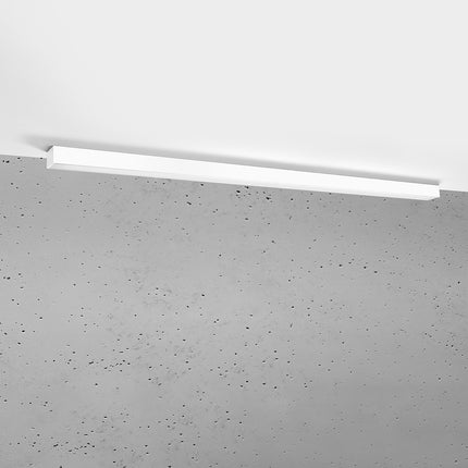 Plafonnier barre moderne LED blanc 150 cm installé au plafond au-dessus d'un mur de béton