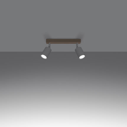 Gros plan sur un spot orientable en acier blanc fixé à la barre en bois massif