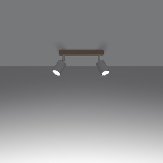 Gros plan sur un spot orientable en acier blanc fixé à la barre en bois massif