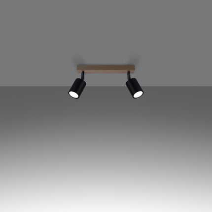 Gros plan sur un spot orientable en acier noir fixé à la barre en bois massif