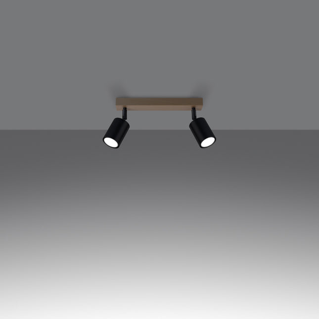 Gros plan sur un spot orientable en acier noir fixé à la barre en bois massif