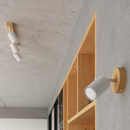 Plafonnier 3 spots blanc éclairant un séjour au mobilier bois clair