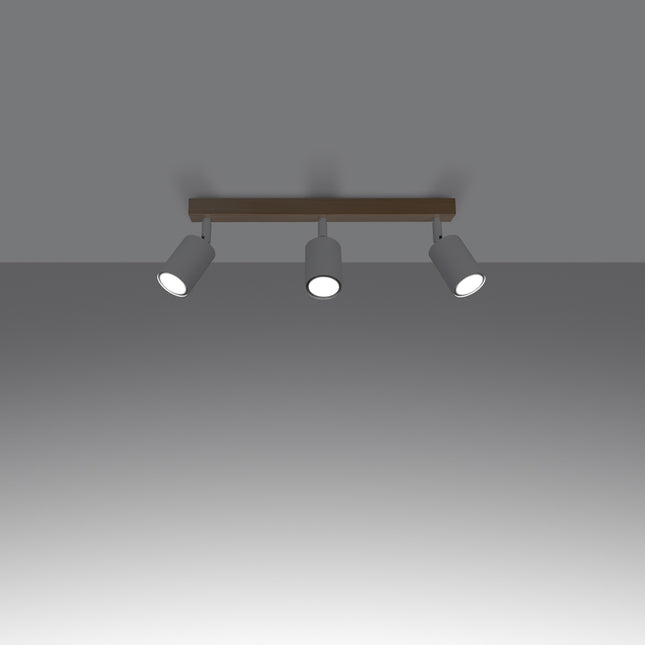Gros plan sur un spot orientable en acier blanc fixé à la barre en bois massif