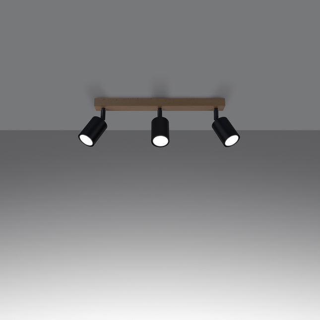 Gros plan sur un spot orientable en acier noir fixé à la barre en bois massif