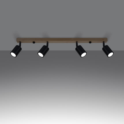 Gros plan sur un spot orientable en acier noir fixé à la barre en bois massif