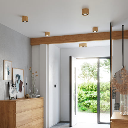 Plafonniers bois naturel installes au plafond d'une entree lumineuse aux murs clairs