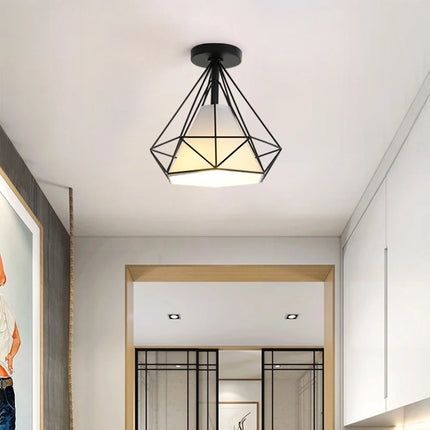 Plafonnier cage diamant en fer noir dans un couloir clair et lumineux