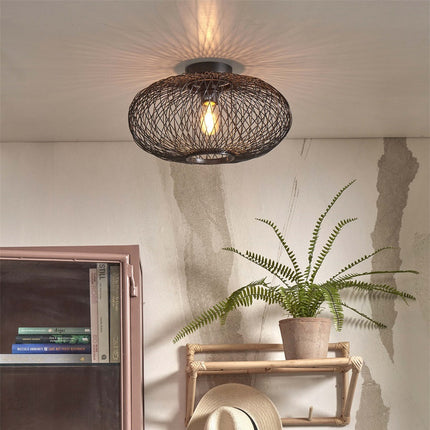 Cango ceiling light in braided black bamboo on the ceiling of a living room, graphic play of shadows on the wall