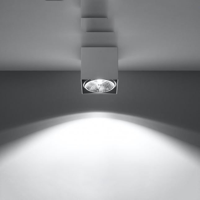 Plafonnier carré blanc allumé projetant un faisceau lumineux net vers le sol sur fond gris
