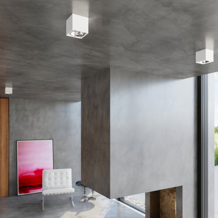 Plafonniers carrés blancs allumés dans un intérieur béton contemporain lumineux
