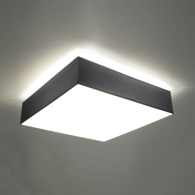 Plafonnier carré gris allumé diffusant une lumière douce et homogène au plafond
