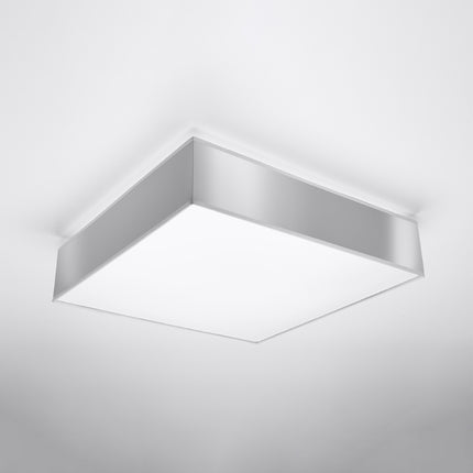 Plafonnier carré gris installé au plafond, vue de trois quarts sur le cadre PVC