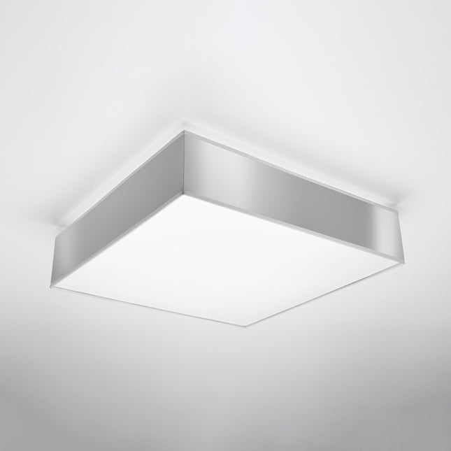 Plafonnier carré gris installé au plafond, vue de trois quarts sur le cadre PVC